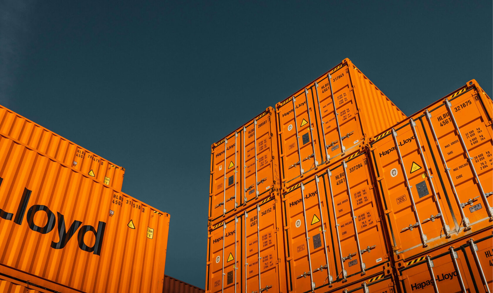 Stacked shipping containers against a dark sky